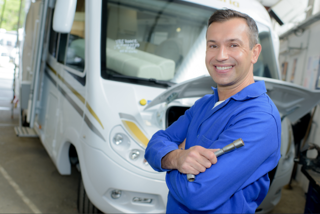 A service technician posing in front of an RV